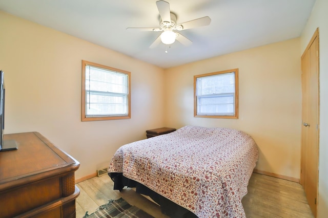 61279 US Highway 169, Hill City, MN 55748 - bedroom featuring baseboards, multiple windows, light wood finished floors, and ceiling fan