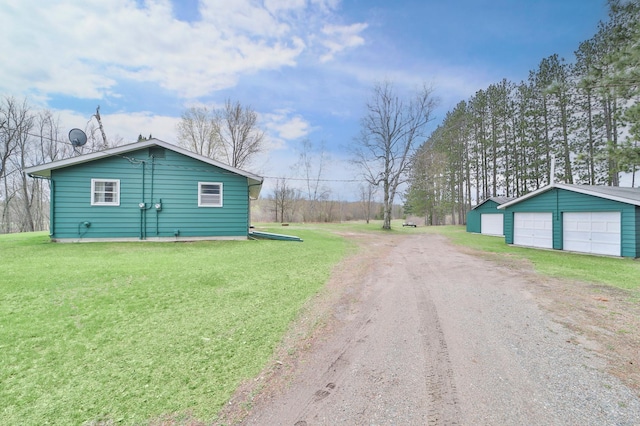 61279 US Highway 169, Hill City, MN 55748 - view of side of home featuring a detached garage, dirt driveway, an outbuilding, and a lawn