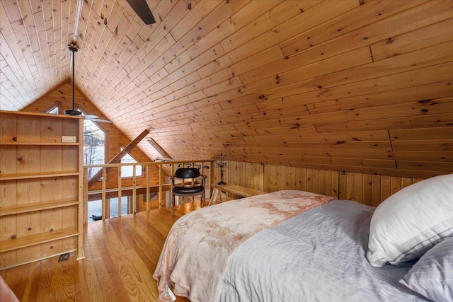 bedroom with lofted ceiling, wooden ceiling, wood finished floors, and wooden walls