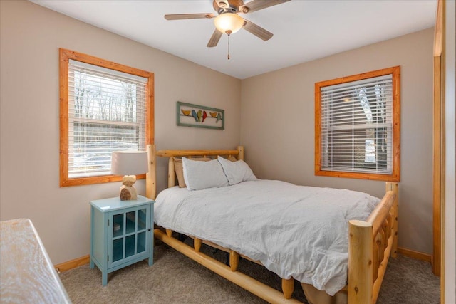 bedroom featuring a ceiling fan, light carpet, and baseboards