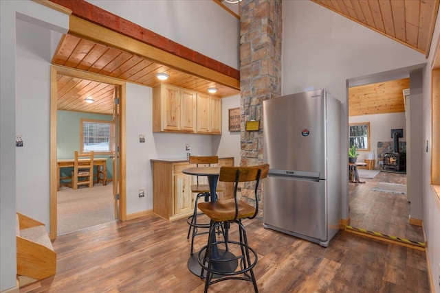 kitchen featuring freestanding refrigerator, wooden ceiling, light brown cabinets, and wood finished floors