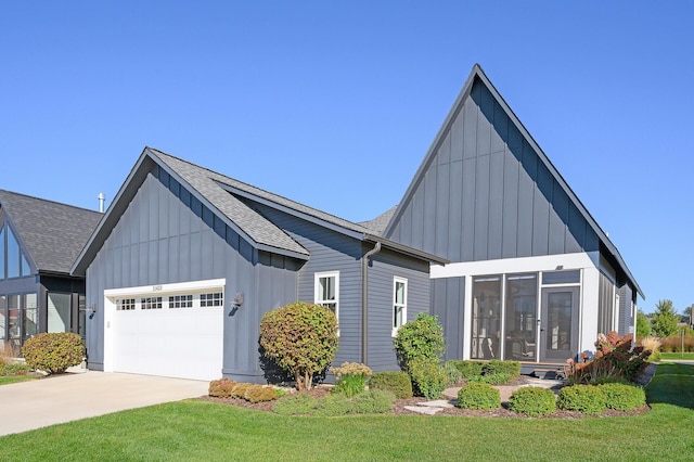 view of front of property with a shingled roof, concrete driveway, board and batten siding, a front yard, and a garage