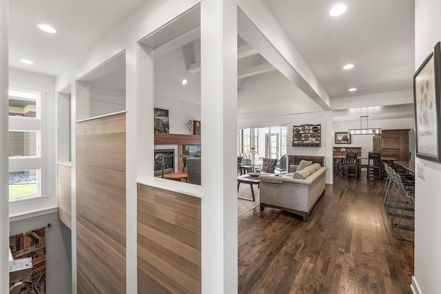 living area featuring dark wood-type flooring, a glass covered fireplace, and recessed lighting