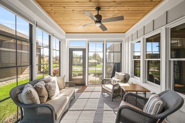 sunroom featuring wood ceiling and a ceiling fan