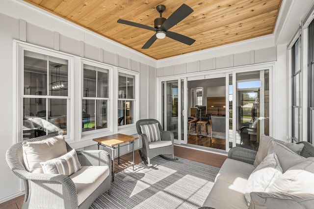 sunroom / solarium with wooden ceiling, a raised ceiling, and a ceiling fan