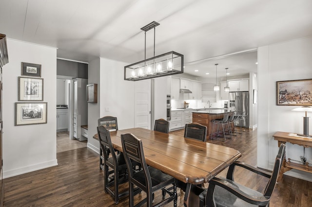 dining room with dark wood-type flooring, recessed lighting, and baseboards