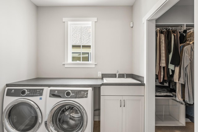 clothes washing area featuring cabinet space, independent washer and dryer, and a sink