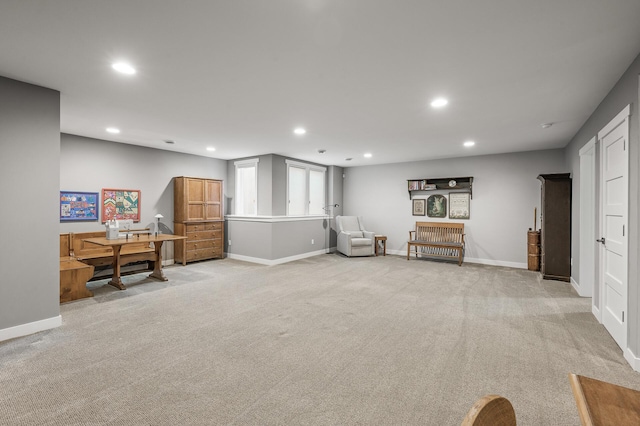 sitting room with recessed lighting, light colored carpet, and baseboards