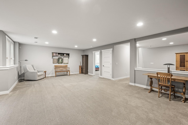 sitting room with baseboards, light colored carpet, and recessed lighting