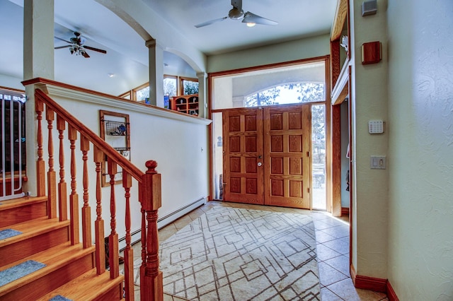 foyer entrance featuring ceiling fan, stairs, decorative columns, and a textured wall