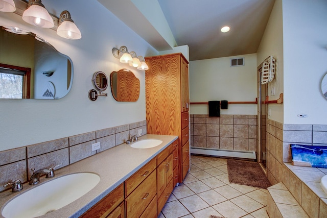 full bathroom featuring a baseboard heating unit, tile patterned flooring, visible vents, and a sink