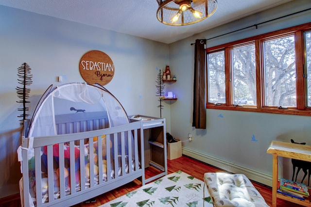 bedroom featuring baseboard heating and wood finished floors