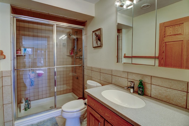 full bathroom featuring toilet, a stall shower, vanity, and tile walls