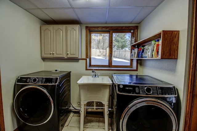 clothes washing area with cabinet space and washer and dryer