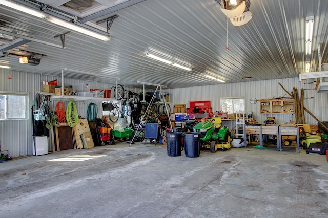 garage with a workshop area, metal wall, and a garage door opener