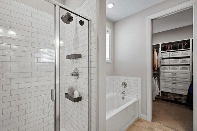 bathroom featuring tile patterned flooring, a shower stall, a walk in closet, and a bath