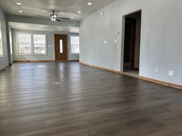 unfurnished living room with recessed lighting, baseboards, ceiling fan, and dark wood-style flooring