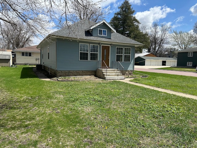 709 4th Ave, Windom, MN 56101 - bungalow-style house with central air condition unit, a shingled roof, and a front lawn