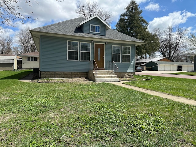 709 4th Ave, Windom, MN 56101 - bungalow-style house featuring a shingled roof, central air condition unit, entry steps, and a front lawn