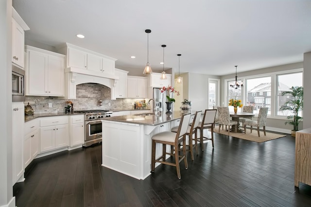 kitchen with appliances with stainless steel finishes, dark wood-type flooring, and decorative backsplash