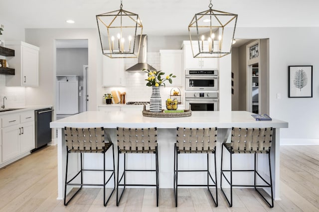 kitchen featuring black dishwasher, a notable chandelier, open shelves, a sink, and wall chimney range hood