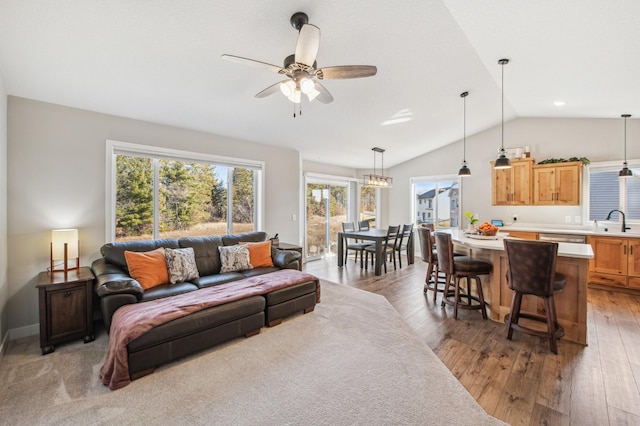 living area featuring vaulted ceiling, ceiling fan, hardwood / wood-style flooring, and baseboards