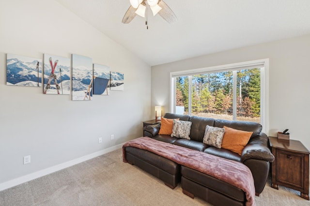 living room with ceiling fan, baseboards, vaulted ceiling, and light colored carpet