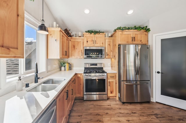 kitchen featuring a sink, light countertops, appliances with stainless steel finishes, dark wood-style floors, and light brown cabinetry