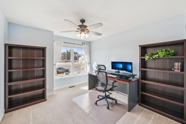 carpeted home office featuring ceiling fan, visible vents, and baseboards