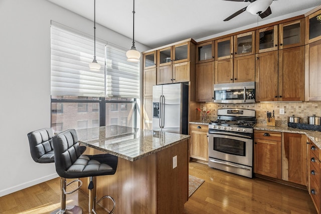 270 4th St E Unit 401, Saint Paul, MN 55101 - kitchen featuring stainless steel appliances, brown cabinetry, ceiling fan, and wood finished floors