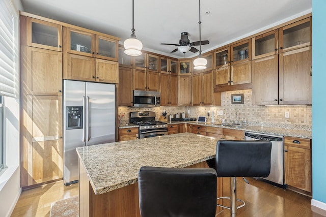 270 4th St E Unit 401, Saint Paul, MN 55101 - kitchen featuring appliances with stainless steel finishes, ceiling fan, a sink, brown cabinets, and decorative backsplash