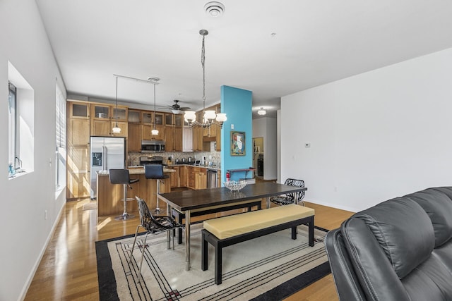 270 4th St E Unit 401, Saint Paul, MN 55101 - dining space featuring a chandelier, baseboards, and light wood-type flooring