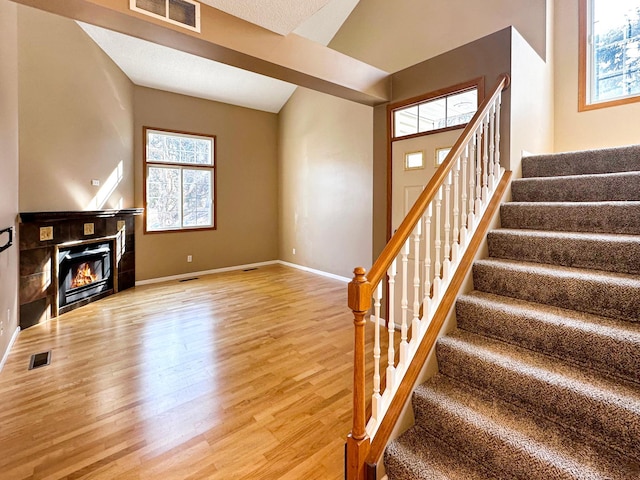 interior space featuring a fireplace, wood finished floors, visible vents, and baseboards