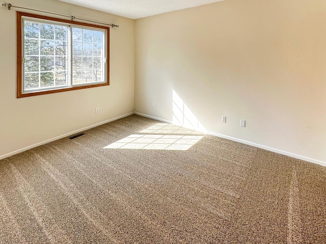 carpeted spare room with baseboards and a textured ceiling