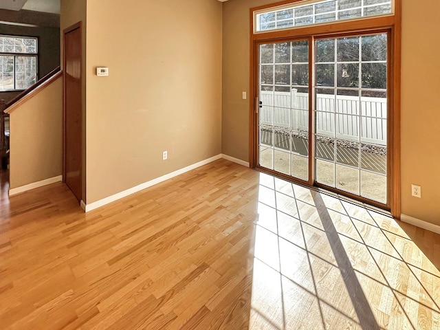 interior space featuring plenty of natural light, light wood-style flooring, and baseboards