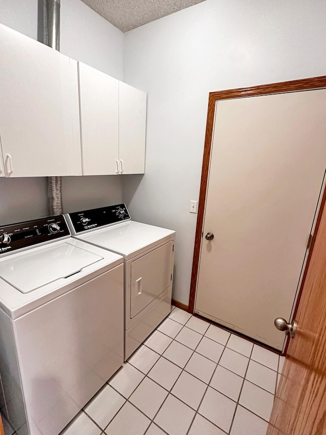 laundry area with a textured ceiling, separate washer and dryer, and cabinet space