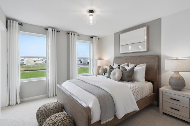 bedroom with light carpet and baseboards