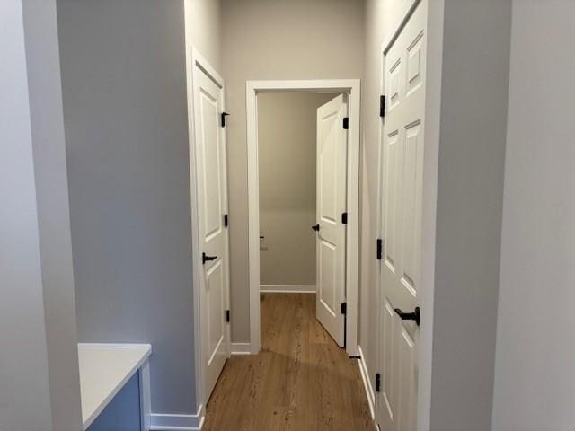 hallway with baseboards and light wood-style floors