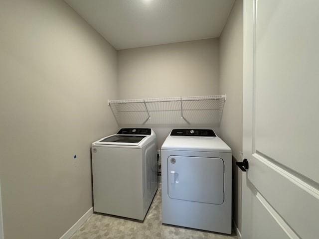 laundry room with laundry area, washer and clothes dryer, and baseboards