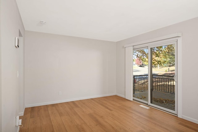 unfurnished room with baseboards, visible vents, and light wood-style floors