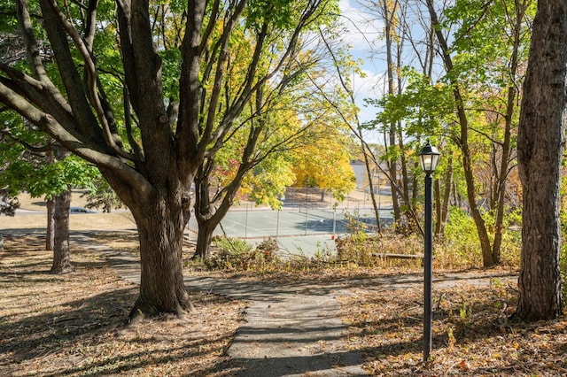 surrounding community with a tennis court