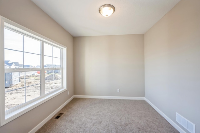 carpeted spare room with baseboards and visible vents