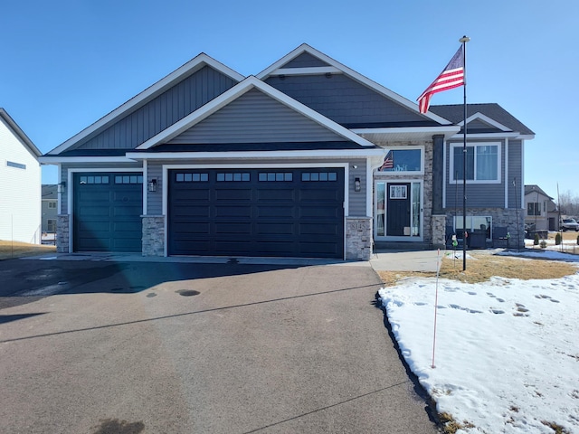 craftsman-style home featuring stone siding, board and batten siding, driveway, and a garage