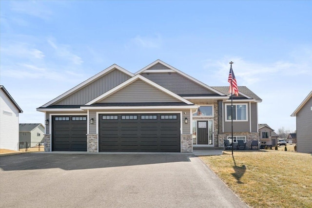 craftsman inspired home featuring driveway, a front lawn, a garage, stone siding, and board and batten siding