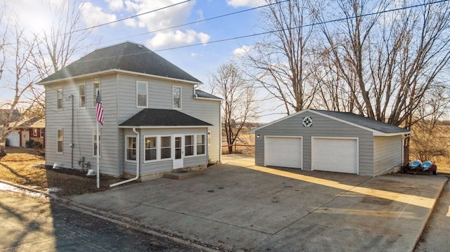 view of front of home featuring a garage, an outbuilding, and a shingled roof