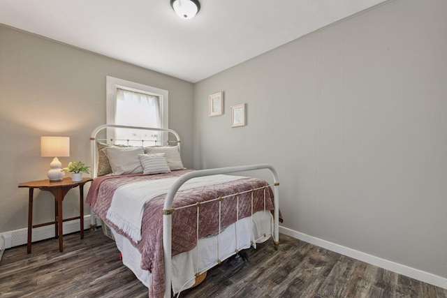 bedroom with dark wood-type flooring and baseboards