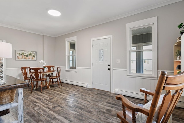 foyer entrance featuring baseboard heating, wainscoting, ornamental molding, and wood finished floors