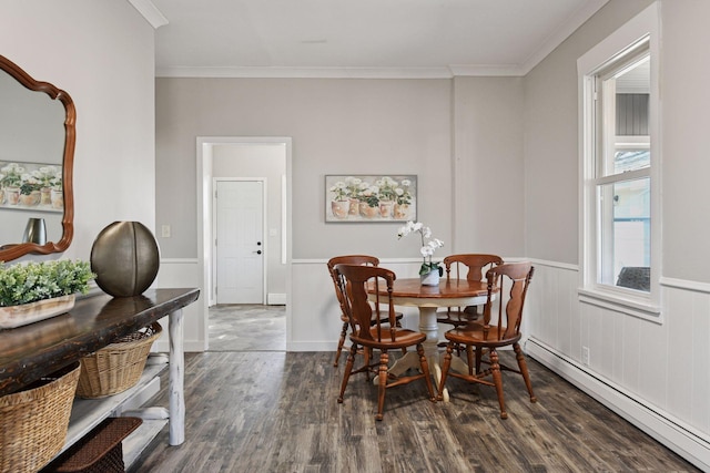 dining room with crown molding, wood finished floors, a wainscoted wall, and a baseboard radiator