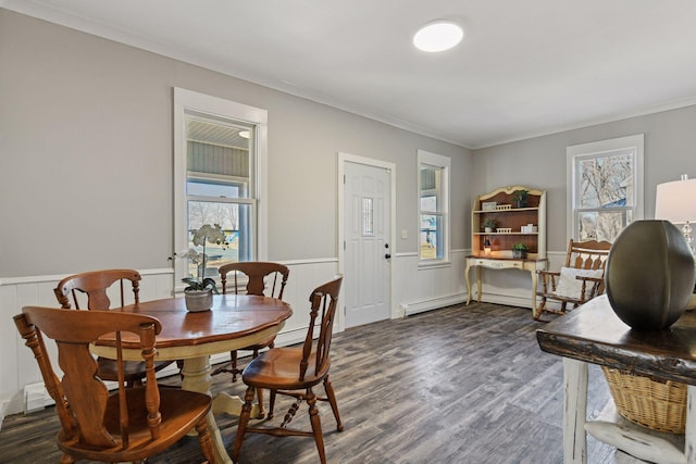 dining area featuring a wainscoted wall, baseboard heating, crown molding, and dark wood-style flooring