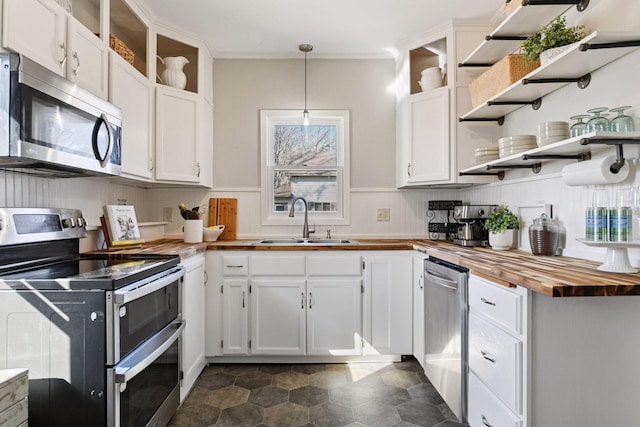 kitchen featuring wooden counters, open shelves, a sink, white cabinets, and appliances with stainless steel finishes